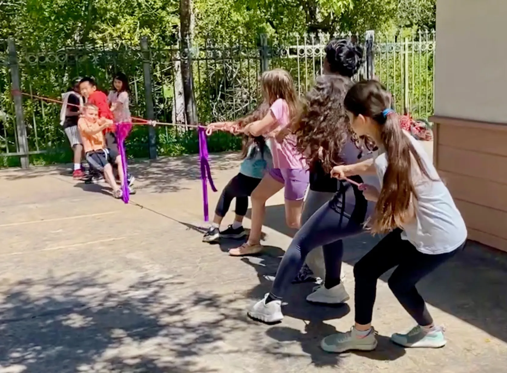 Elementary kids challenge middle-school kids in a round of Pulley-Tug-of-War.